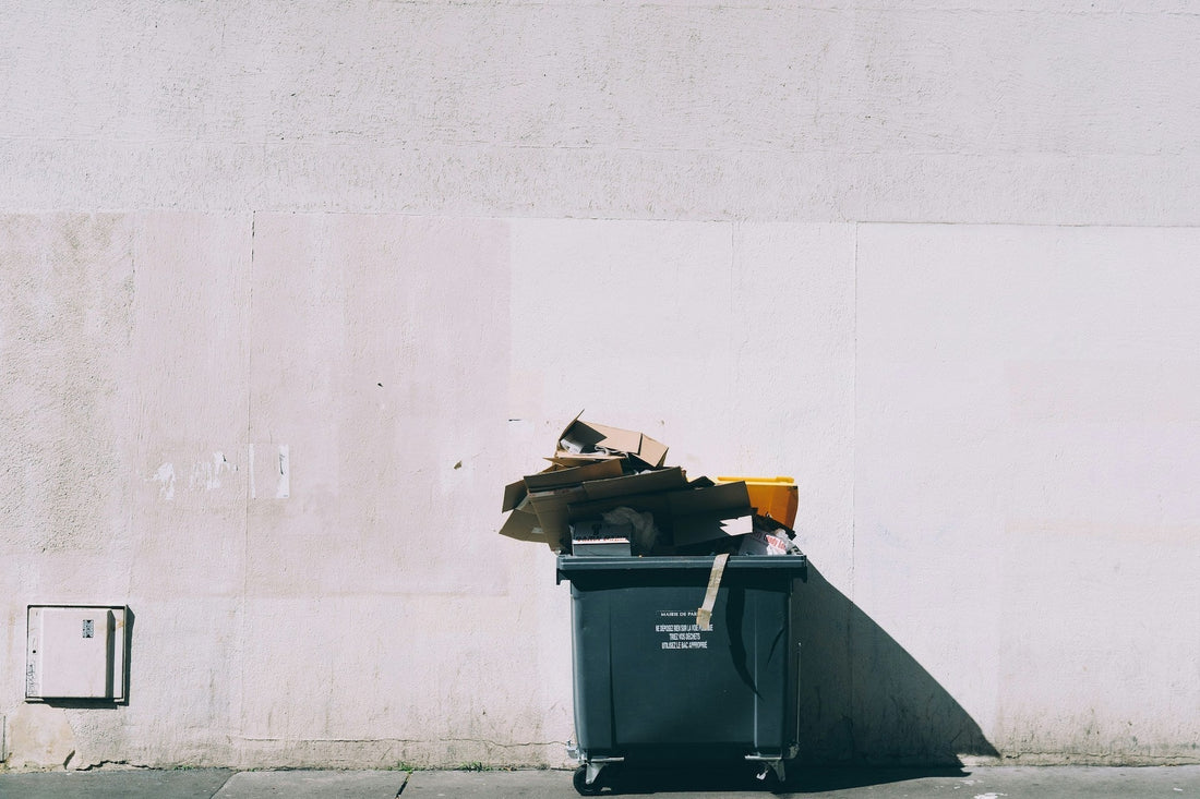 Garbage Bin in Paris filled with boxes of luxury brands
