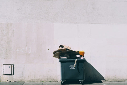 Garbage Bin in Paris filled with boxes of luxury brands