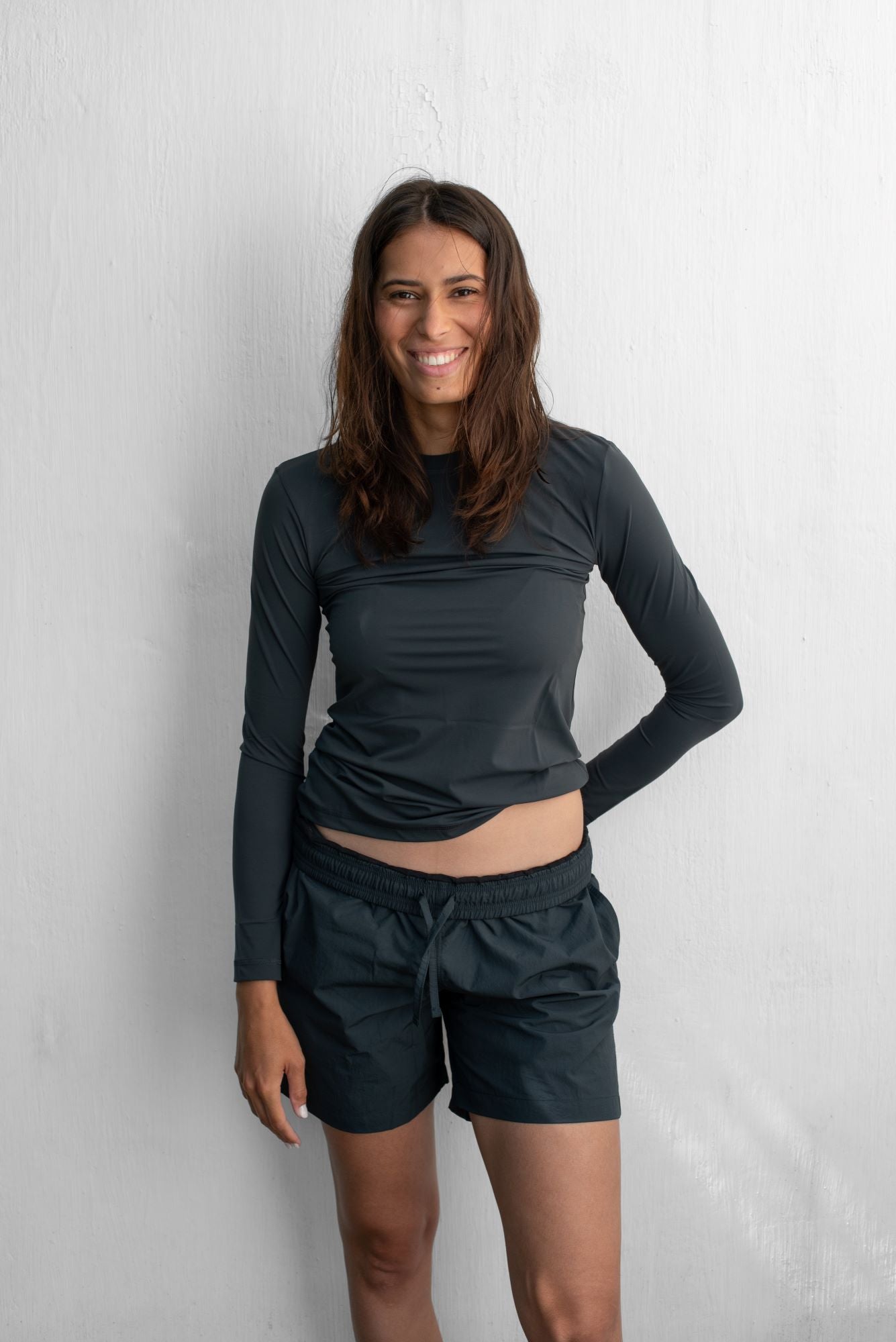 Woman wearing a sustainable dark grey SPF50+ long sleeve rashguard