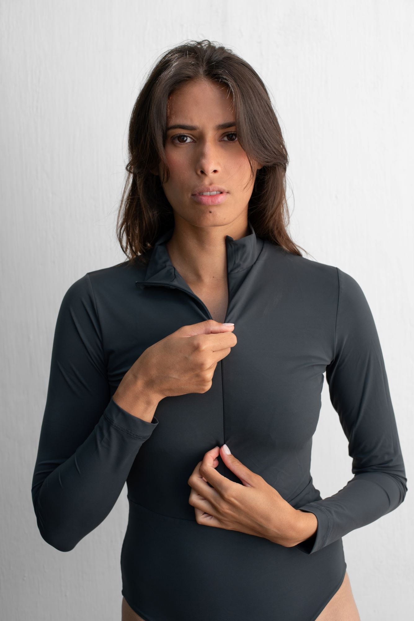 Woman wearing a sustainable dark grey SPF50+ long sleeve swimsuit